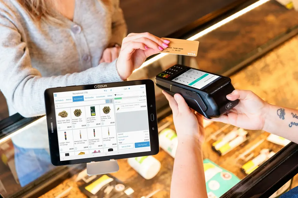 Pago con tarjeta en un terminal junto a una caja en tablet